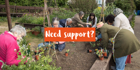 A group of people of varying ages and ethnicities gardening in a raised bed in an urban environment with the text 'Need support?' across the image
