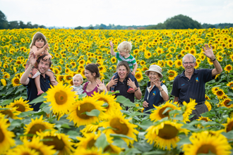 Family with Nicholas Watts' younger grandchildren enjoying sunflower fields at Vine House Farm
