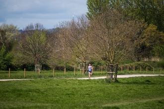 Runner on path between trees at Riverside Valley Park