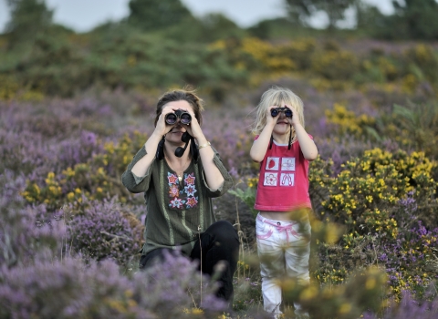 Child with their mother using binoculars