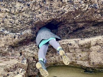 Person climbing in a rockpool