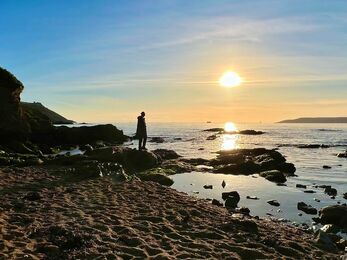 Person at a rockpool at sunset 
