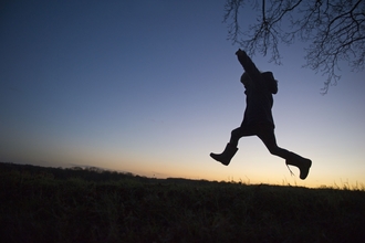 Child leaping against sky-line