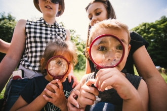 Children at an event using magnifying glasses
