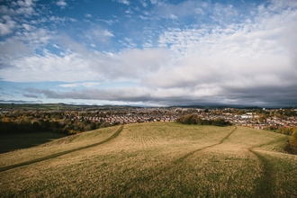 A grassy field wit Exeter city in the background