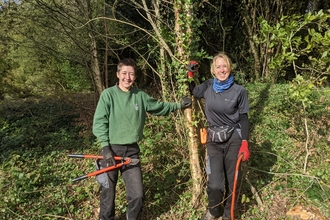 Photo of Zofia and Caroline wild paths trainees holding tools