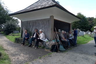 Group of people sitting around a small outbuilding