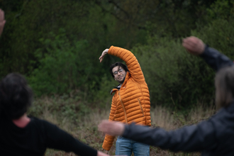 Man stretching arm in wooded area