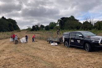 A group of volunteers working at a reserve, a vehicle and team