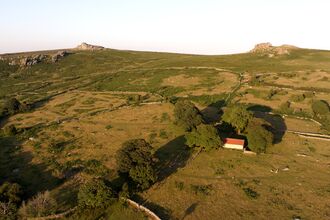 hillside with the rocky tors at the top, farmland and buildings alongside wildlife rich habitat