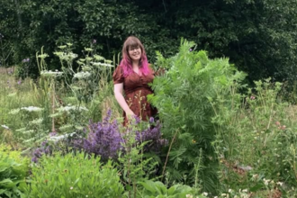 Jenny smiling in a wonderful flowering garden