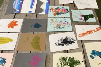 a wooden table with pieces of lino artwork laid out on it
