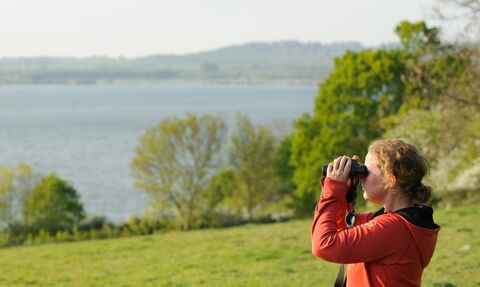 Young woman birdwatching at Rutland Water