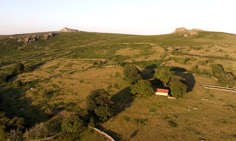 hillside with the rocky tors at the top, farmland and buildings alongside wildlife rich habitat