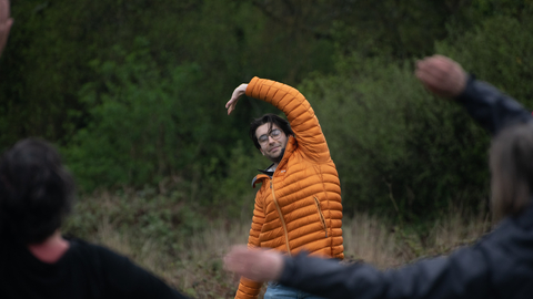 Man stretching arm in wooded area