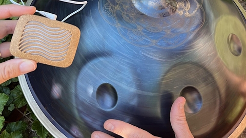 metal handpan with dents that when drummed create different musical notes