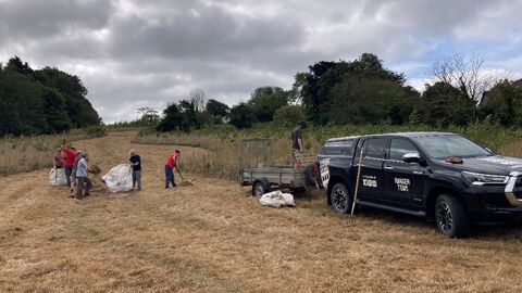 A group of volunteers working at a reserve, a vehicle and team