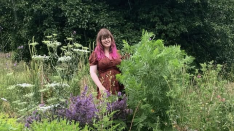 Jenny smiling in a wonderful flowering garden