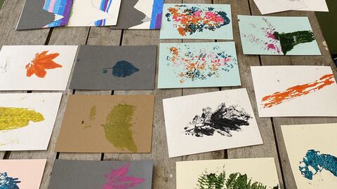 a wooden table with pieces of lino artwork laid out on it