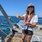 Woman holding container while standing on a boat in the sea