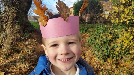Child with a leaf crown at forest school