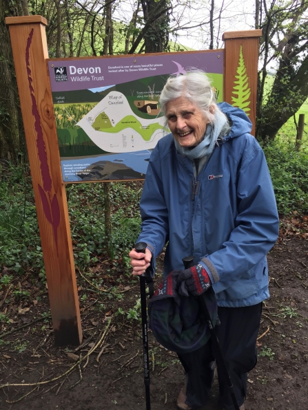 Woman stands in front of nature reserve sign