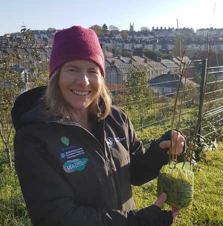 Helen holding up young tree