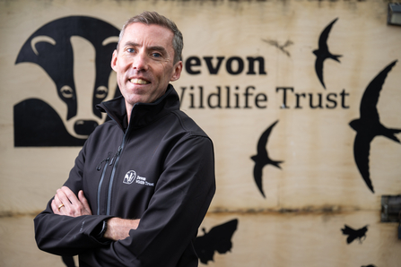 Nick Bruce-White standing in front of Devon Wildlife Trust sign