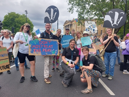 Group of DWT staff and supporters holding placards on road