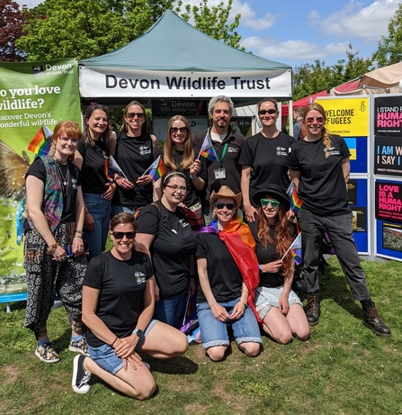 DWT staff standing in front of gazebo at Exeter Pride with rainbow flags