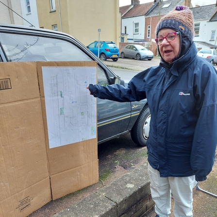 Woman next to a map of the neighbourhood