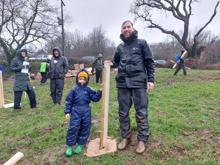Nick BW stood proudly next to child with the tree they have just planted
