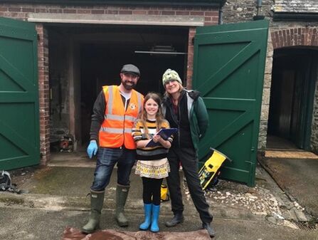 Tom in high-vis standing proudly with his family