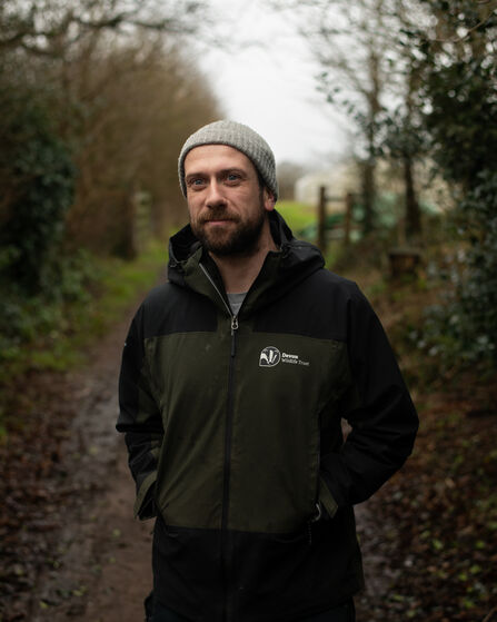 Michael Rogers looking at the camera, stood on a path with hedgerows either side
