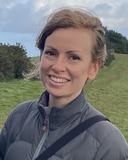 Head and shoulder shot of Annie smiling at the camera whilst on a walk