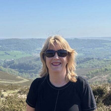 Sara Papworth smiling at the camera, with hills behind