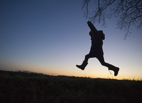 Child leaping against sky-line