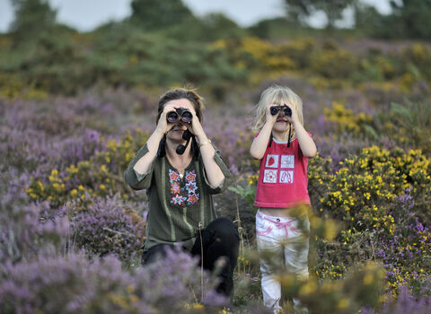Happy family birdwatching among heather