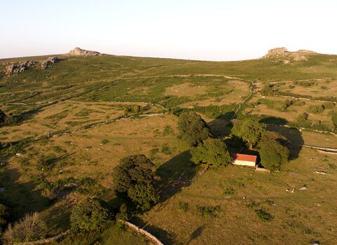 hillside with the rocky tors at the top, farmland and buildings alongside wildlife rich habitat